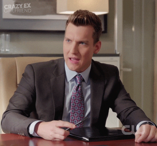 A man in a black suit and tie angrily saying he's nice.