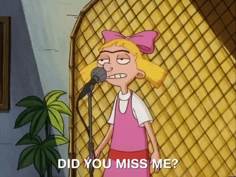 A cartoon girl with blonde hair and a pink dress saying, "Did you miss me?" in front of a microphone stand.
