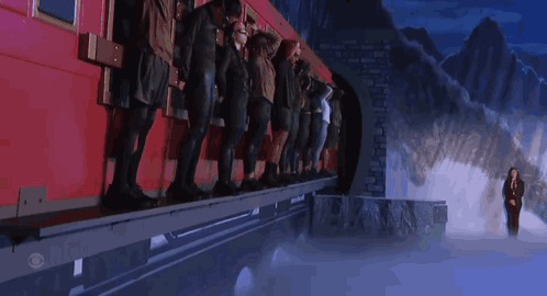 People leaning against a wall being splashed with green goo