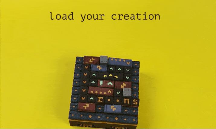 This animated GIF begins by showing a square device that is a grid with colorful, tactile tiles, each marked with symbols, arrows, and letters. The text “load your creation” appears at the top, and a hand places several small brass balls on different grid points while the text above changes to "initialize data". Then the text changes to "activate the circuit", and the hand begins to turn a small crank attached to the device. The grid pieces begin rising and lowering, moving the balls around, and the text says "(this one adds binary numbers together)".