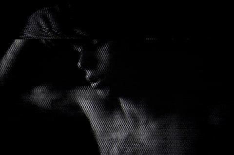 black and white gif of a shirtless boy touching his forehead