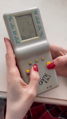 Two hands playing a Tetris game