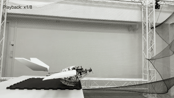 A looping, animated gift showing a robotic drone -- that looks a little bit like a bird -- jumping into the air. Its body is made of black, thin, mechanical parts, and its wings are long wide, and white.