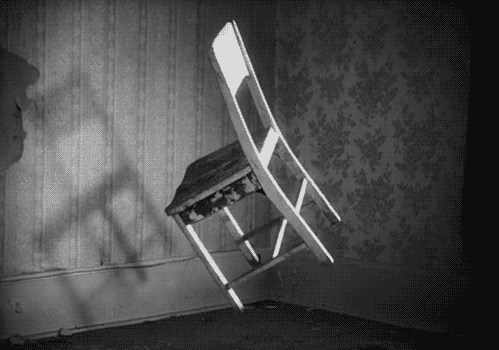A black and white image of a chair rotating in the air