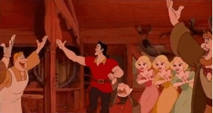 A well-built man in a red shirt saluting a crowd of admirers.