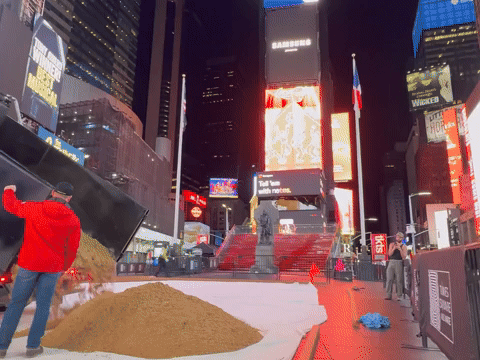 dump truck spreads sand in Times Square