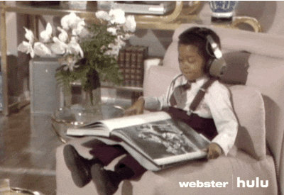 child wearing headphones flipping through a large book