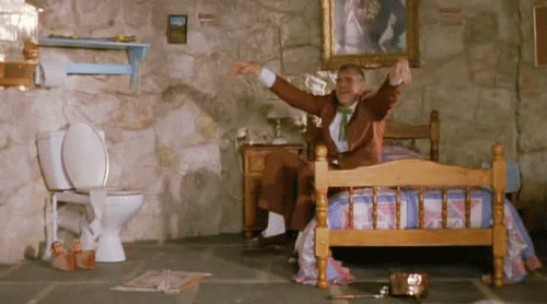 Steve Marting sitting on the side of a bed and stamping his feet on the floor.