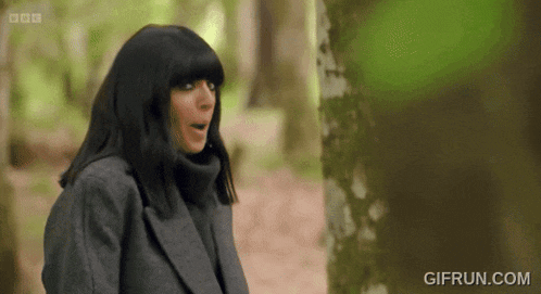 a woman in the woods placing her hands on her face in surprise