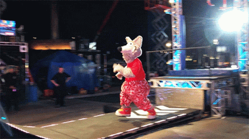 a mascot running up a curved wall and sliding down