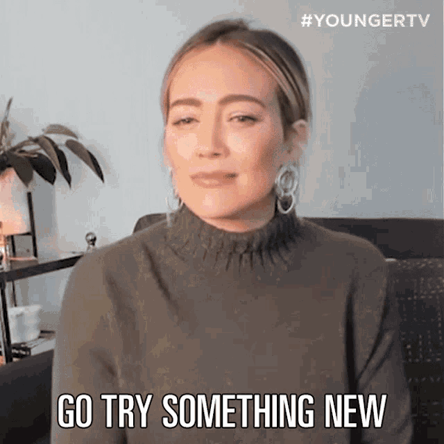 a woman in a sweater with the text "go try something new"