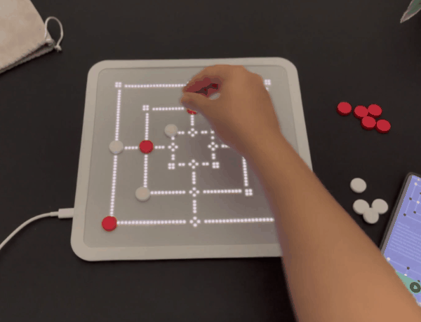 An animated gif of a game board that is composed of a grid of hundreds of tiny white LEDs. As we watch, the game board changes so it becomes several different games