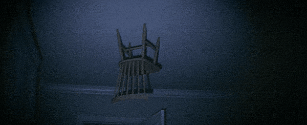 A chair is upside down resting on the ceiling. A yellow frame appears around it with identifying information.
