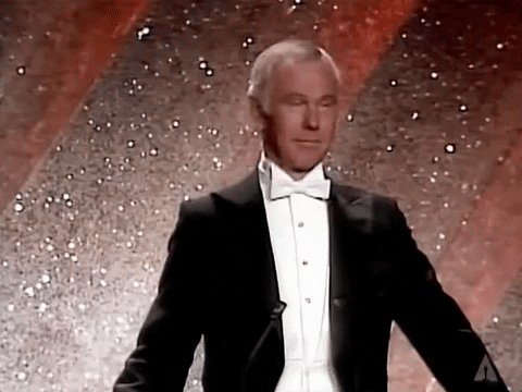 An older white man with white hair and a tuxedo, rolling his eyes.