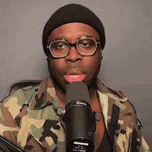 A person behind a microphone putting their hands to their face in shock