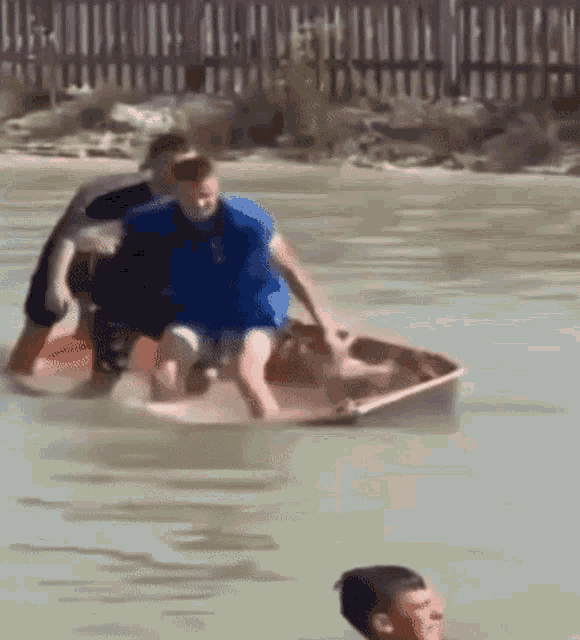 a group of people standing in a small boat that's sinking