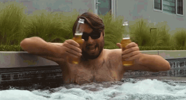 a man drinking beer in a hot tub