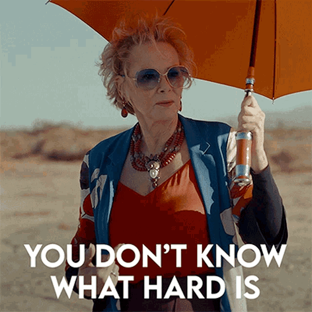 a woman holding an umbrella saying YOU DON'T KNOW WHAT HARD IS