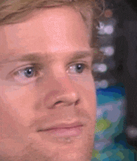 A white man is blinking and raising his eyebrows in surprise.
