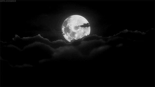A full moon with black clouds drifting across it