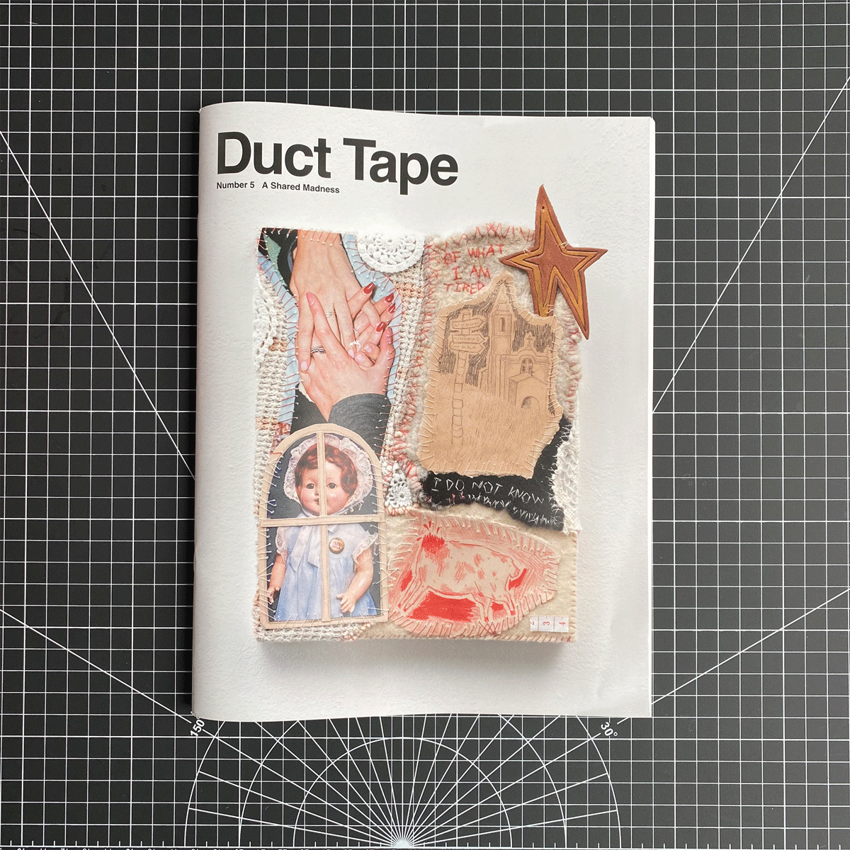 Cover of Duct Tape Magazine, Number 5: A Shared Madness. The collage-style cover shows interlaced images including two hands holding, a doll’s face framed by a window shape, a stitched star, and textured fabric details. A hand flipping through two interior spreads.