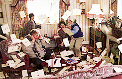 A family is in a livng room that has letters falling through the air all around them.