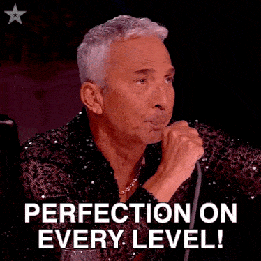 a man holding a microphone and saying perfection on every level