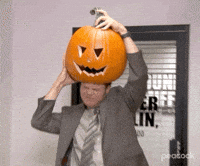 A GIF from the Office of Dwight Shrute trying to stuff a pumpkin onto his head.