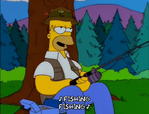 A GIF of Homer Simpson sitting on the grass by a tree with a fishing pole singing, "Fishing, Fishing."
