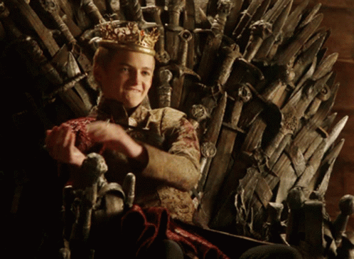 a man sitting on the iron throne clapping