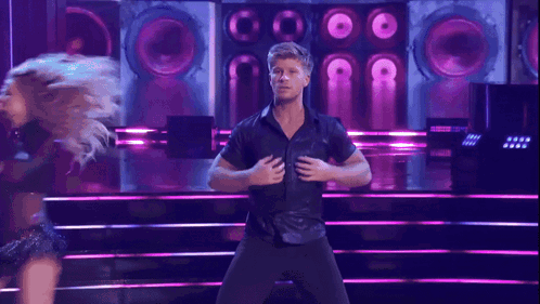 A dancing man tears open his shirt and takes it off