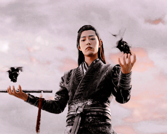 image of cultivator from Chinese wuxia drama The Untamed Wei Wuxian holding two pieces of the Yin Tiger Amulet, each of them covered in shadowy resentful energy