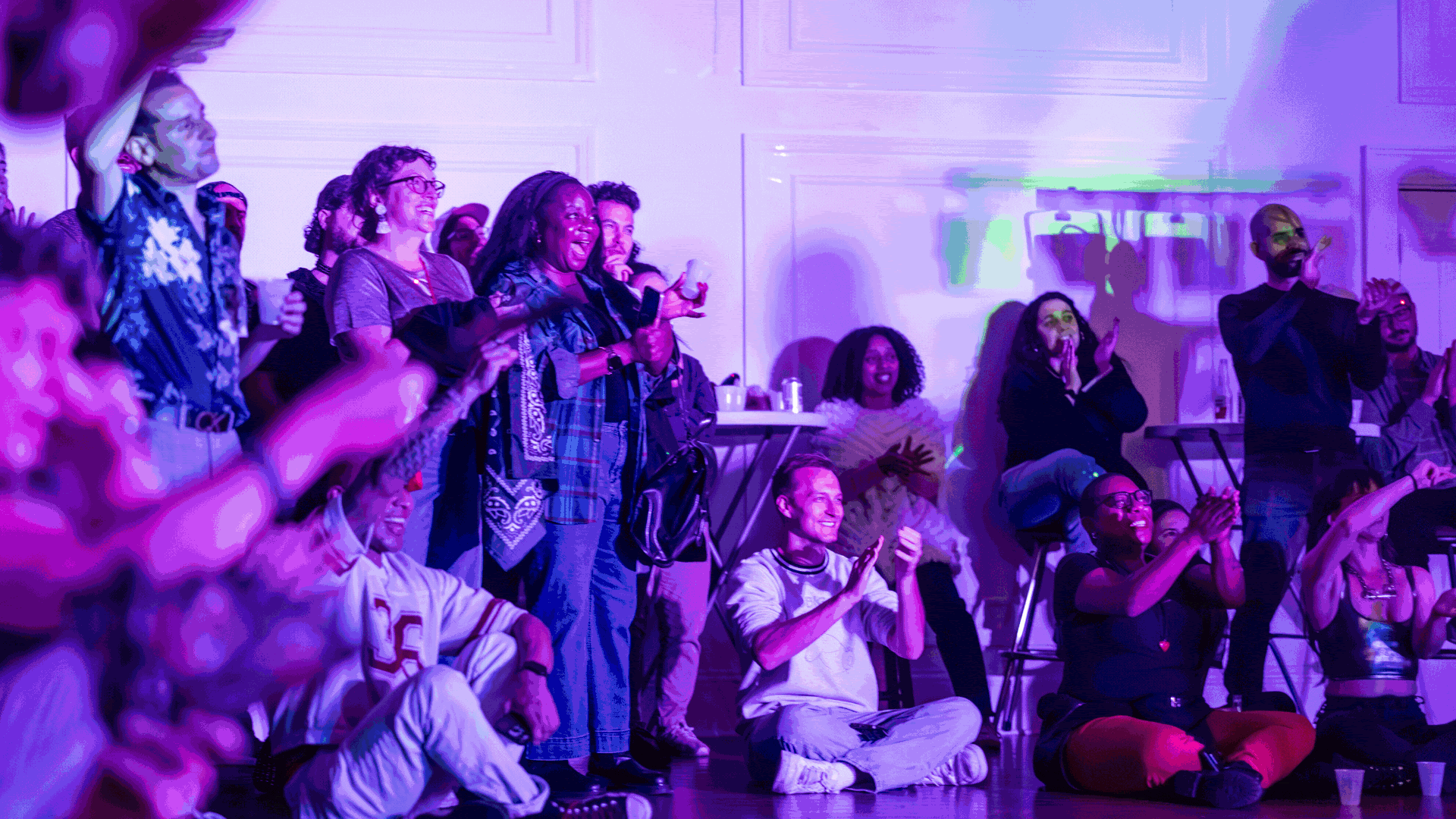 a carousel of party scene imagery: drag queens and burlesque performers and clapping audience members under bright colorful lights