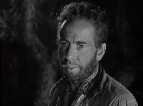 A black-and-white image of man with a beard and disheveled hair saying, "We got no use for you."