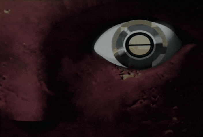 Malice standing before a giant red moon structure